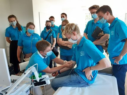 Junge Leute in blauen T-Shirts an medizinischem Gerät