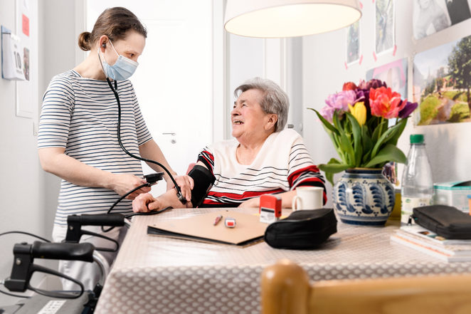 Junge Ärztin mit älterer Patientin